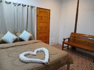 a bedroom with a heart shaped bed with a bench at Ao Yai Homestay Koh Kood in Ko Kood +22 photos