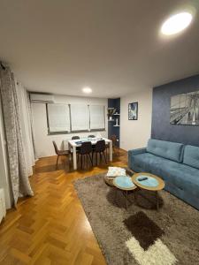 a living room with a blue couch and a table at Blue harmony SB in Slavonski Brod