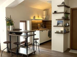 a kitchen with a table and stools in a room at Studio Béni in Smolyan