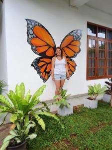 a woman standing in front of a butterfly sculpture at Costels Mirissa in Mirissa