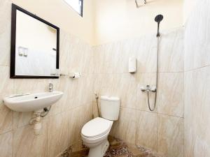 a bathroom with a toilet and a sink and a shower at Alam Citra BnB Mitra RedDoorz in Yogyakarta +28 photos