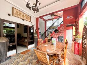 a dining room with a table and chairs and a staircase at Alam Citra BnB Mitra RedDoorz in Yogyakarta