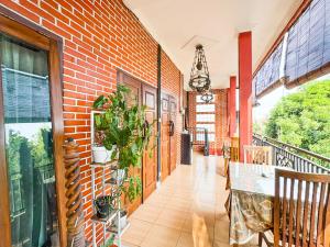 a balcony with a brick wall and a table at Alam Citra BnB Mitra RedDoorz in Yogyakarta