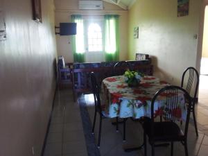 a dining room with a table with flowers on it at Palm View Room 1 in Christ Church