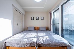 a bedroom with a bed and a large window at Zabo Hills 205 in Sapporo