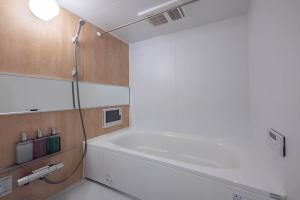 a bathroom with a bath tub and a sink at Zabo Hills 205 in Sapporo