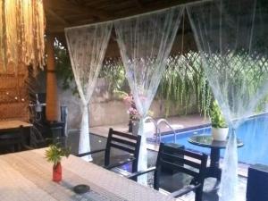 a patio with a table and chairs next to a pool at New Coco cabana in Bentota