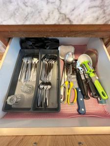 a drawer filled with utensils on a table at Century Suria Seaview + 3 Bedroom Apartment in Kuah