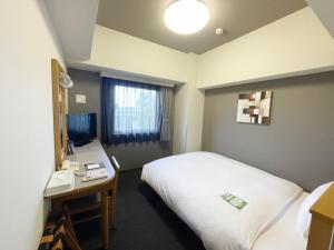 Postel nebo postele na pokoji v ubytování Hotel Route-Inn Tsubamesanjo Ekimae