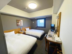 Postel nebo postele na pokoji v ubytování Hotel Route-Inn Tsubamesanjo Ekimae