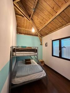Litera en habitación con techo de madera en Villa meublé Tourisme 4 etoiles Sous le Ficus piscine chauffée - Ouest Lagon, en Saint-Paul
