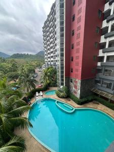 a large swimming pool next to a tall building at Century Suria Seaview + 3 Bedroom Apartment in Kuah