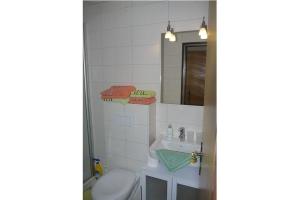 a bathroom with a toilet and a sink and a mirror at Kiebitzei in Wittdün