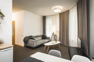 een woonkamer met een bank en een tafel bij Bearsleys Archers Apartments in Rīga