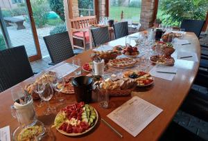 a long wooden table with plates of food on it at Penzion u Dyje in Bulhary