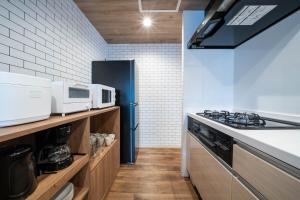a kitchen with a stove top oven next to a counter at Zabo Hills 303 in Sapporo