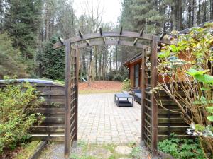 une porte en bois menant à une terrasse dans le jardin. dans l'établissement Chalet in a peaceful location in a forest near Nijlen, à Nijlen