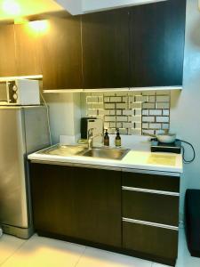 een keuken met een spoelbak en een koelkast bij One Bedroom Loft in the heart of Greenbelt Makati in Manilla