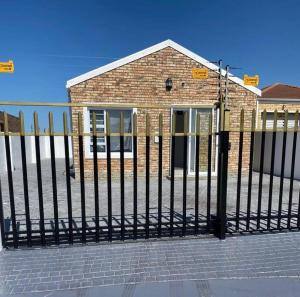 una recinzione nera di fronte a un edificio di mattoni di The Zebra a Gqeberha