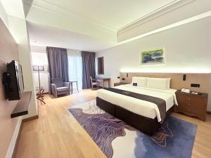 a hotel room with a large bed and a desk at The Pearl Kuala Lumpur in Kuala Lumpur
