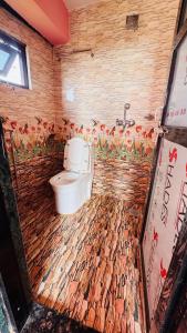 a bathroom with a toilet in a brick wall at Bandipur Pradhan Homestay in Bandipur