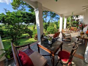 a porch with chairs and a table with a view at Villa Albizia, Chiang Mai in Doi Saket