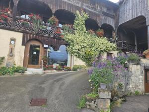 a building with flowers on the side of a street at relais de la diligence in Morteau