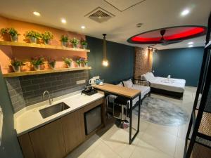 una cucina con lavandino, tavolo e divano di Smile Hotel Chow Kit PWTC a Kuala Lumpur