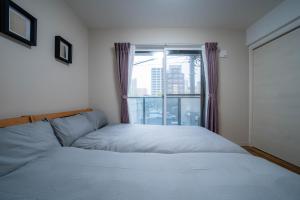 a bedroom with two beds and a window at Zabo Hills 305 in Sapporo