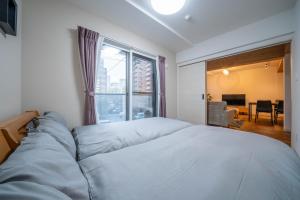 a bedroom with a large bed with a large window at Zabo Hills 305 in Sapporo