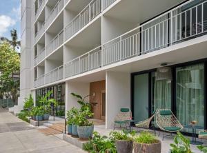 an exterior view of a building with chairs and plants at Romer House Waikiki in Honolulu