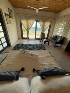 two beds in a room with a view of the ocean at Coconut Resort in Tuléar