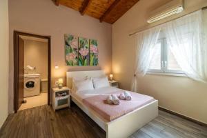 a bedroom with a bed with two shoes on it at Villa Rose by PosarelliVillas in Georgioupolis +32 photos