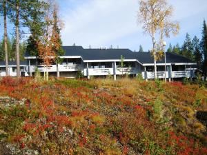 a large house in a field of red flowers at Kuerkaltio Resort in Äkäslompolo