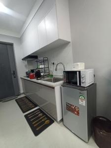 a small kitchen with a sink and a microwave at Bela Homes Large Deluxe studio Apartment in Nairobi