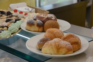 three plates of pastries on a table with other desserts at Catania Etnea Bed and breakfast in Catania