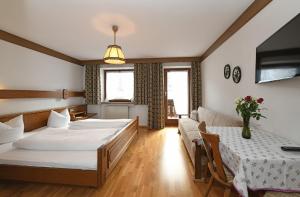 a hotel room with two beds and a couch at Haus Marlene in Schoppernau