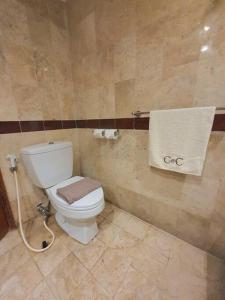 a bathroom with a toilet and a towel at C&C Jayakarta Apartment Legian Bali A in Seminyak
