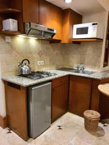 a kitchen with a stove and a microwave at C&C Jayakarta Apartment Legian Bali A in Seminyak