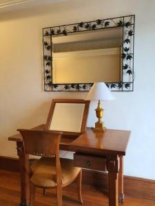 a wooden desk with a lamp and a mirror at C&C Jayakarta Apartment Legian Bali A in Seminyak +41 photos