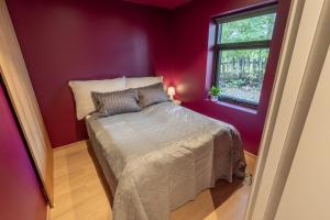 a bedroom with a bed in a red room at Town house with good view on top of Tromsø Island in Tromsø