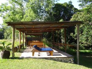 eine hölzerne Pergola mit einem Picknicktisch und Bänken in der Unterkunft Sweetwater Lodge in Julatten