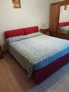 a red bed in a room with a mirror at Charming House in Barbarano Romano with Terrace and Fireplace in Barbarano Romano