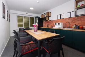 a kitchen with a wooden table and black chairs at Atakent Hostel in Almaty