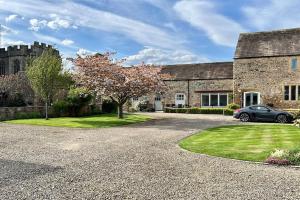 a house with a car parked in front of it at Parr Cottage at Snape Castle Mews in Bedale