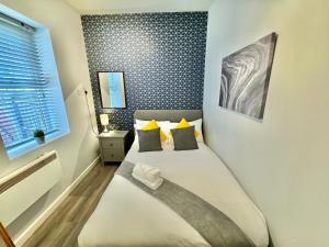 a small bedroom with a bed with yellow pillows at Two Bedroom Apartment - Heart of Bournemouth - Free Parking - Sleeps 6 - Close to Town and Beach in Bournemouth
