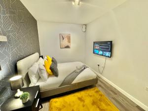 a room with a bed and a tv on a wall at Two Bedroom Apartment - Heart of Bournemouth - Free Parking - Sleeps 6 - Close to Town and Beach in Bournemouth