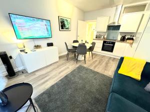 a living room with a couch and a table with chairs at Two Bedroom Apartment - Heart of Bournemouth - Free Parking - Sleeps 6 - Close to Town and Beach in Bournemouth +4 photos