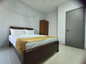 a bedroom with a large bed with a wooden headboard at Raya hotel juba in Juba