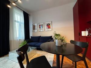 a living room with a table and a blue couch at Downtown Oasis-City center and Quiet, Self Check in Cluj-Napoca